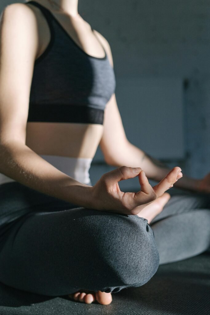 A woman practicing yoga indoors in a peaceful environment, focusing on mindfulness and relaxation.